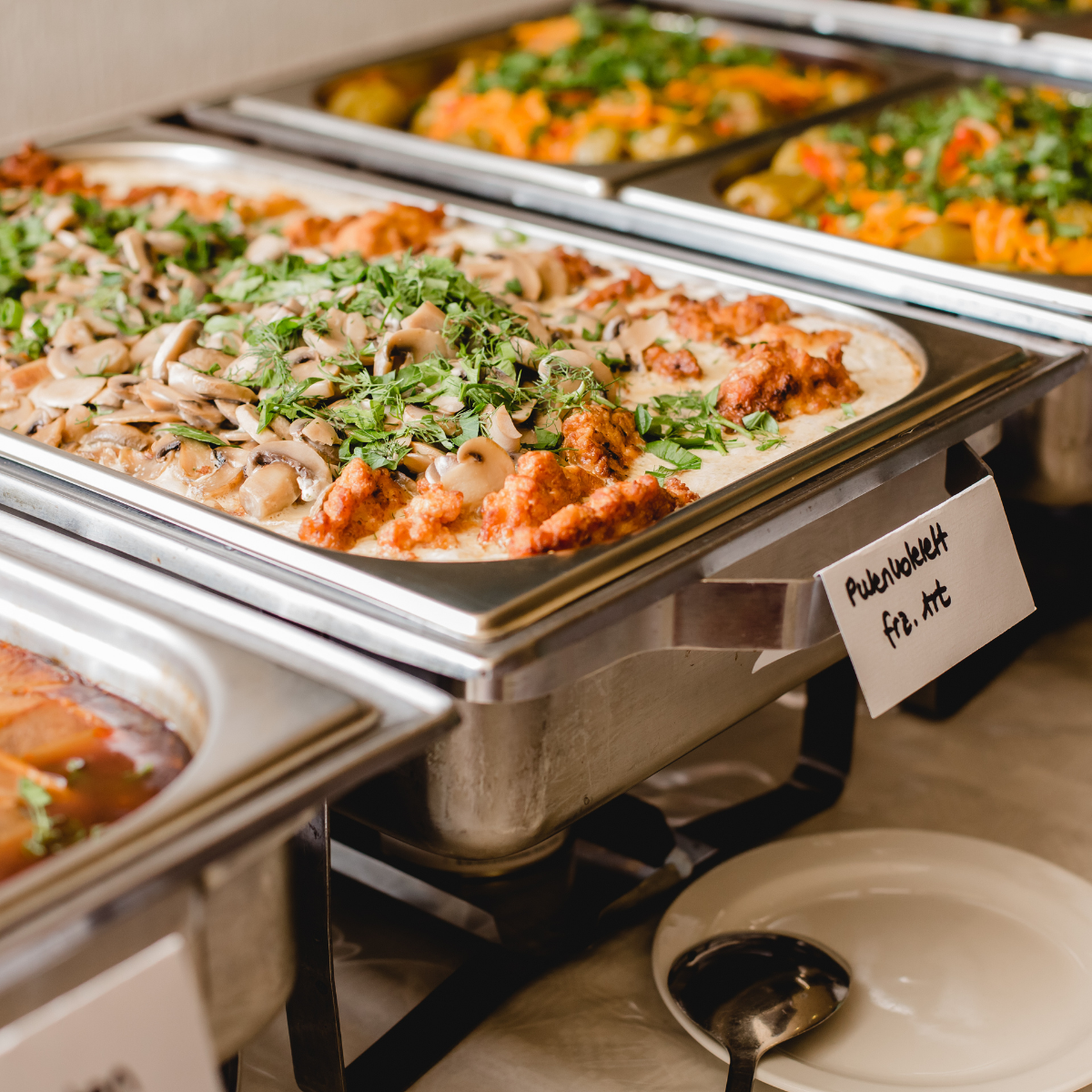 interactive-pasta-bar A catering buffet features several warm dishes in chafing units, including a pasta dish.