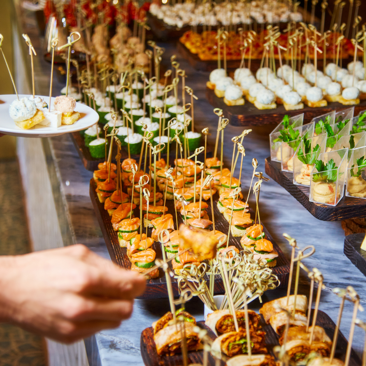 late-night-bites Catered appetizer spread featuring sliders and savory pastry rolls on wooden boards.
